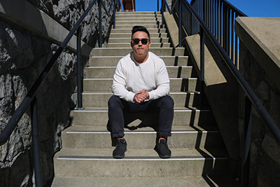 Trevor Wong sitting on some stairs at Bear Mountain in Victoria, BC.